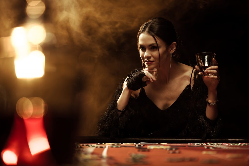 gorgeous young woman sitting at poker table with g AGA7GFD